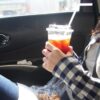 コーヒーを車で飲む女性
