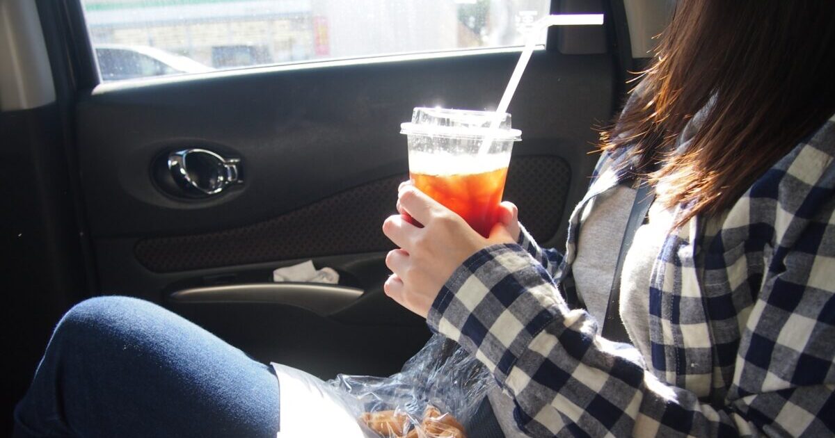 コーヒーを車で飲む女性